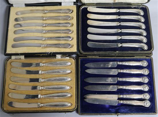Four cased sets of six silver handled cake knives.